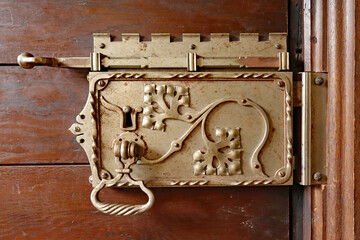 Fototapeta na wymiar An ornate door lock mechanism decorated with vines and leaves in an English country house