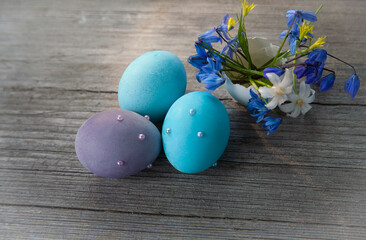easter blue eggs and spring blue flowers in the egg on wooden table