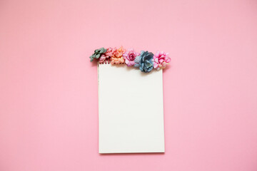 notebook decorated with multicolored flowers on a pink background. concept for March 8 and spring.
