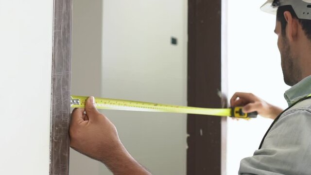Inspector engineers are checking the width of the doorway in the construction site.