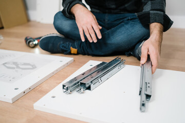 Portrait of man assembling furniture. Do it yourself furniture assembly.