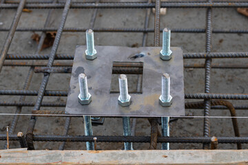 Light pole base and anchor bolts in concrete base. Concrete base construction with light pole base.