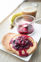 
Homemade oatmeal and banana pancakes with red berry jam, light food photography