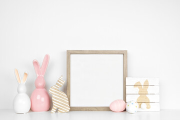 Mock up wood frame with Easter decor on a white shelf. Shabby chic wood sign, modern glass bunnies....