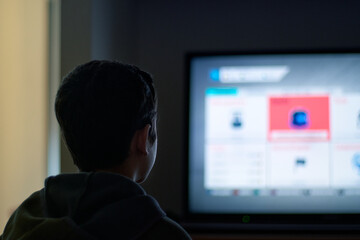 Young boy plays videogame at home during covid time.