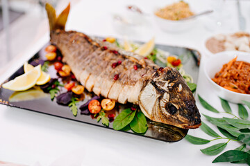 beautiful serve baked whole and sliced into pieces of fish. river and marine products. menu for the holiday. serving the table.