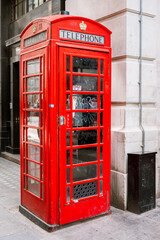 Old traditional red telephone booth on a street in the city of London