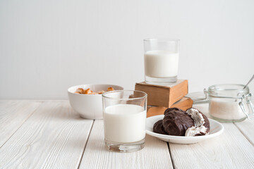 Milk breakfast with crackers and marshmallows on a white background with books. Side view, with space to copy. The concept of dairy products.