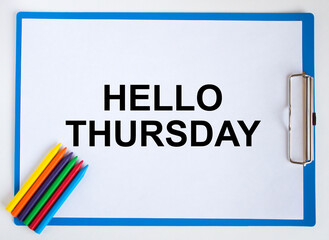 Colored pencils and clipboard with a text Hello Thursday