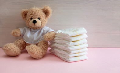 Baby girl diapers, teddy sitting on pink color floor