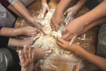 A view from above of teaching children the culinary arts. Hands of children and masters. High quality photo