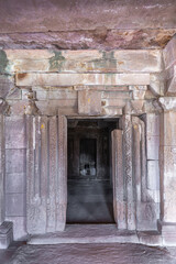 Fototapeta na wymiar Aihole, Karnataka, India - November 7, 2013: Chakra Gudi temple. Inside in front of inner sanctum with Shivalingam. Monumental stone sculpted door frame and opening.