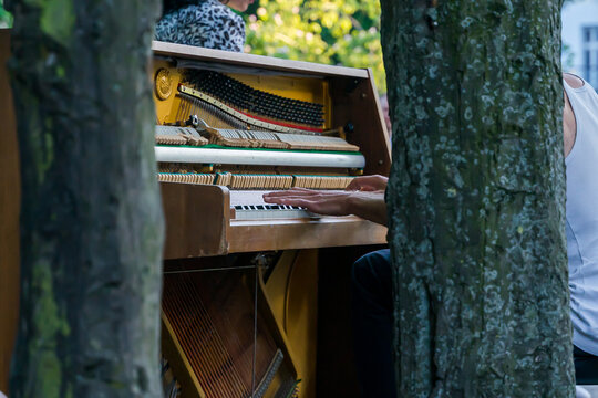Pianist playing piano on the street. Street musician performing with piano on the street