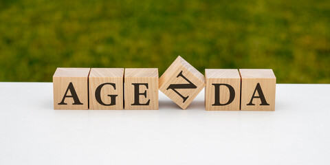 Agenda - words from wooden blocks with letters, agenda item list concept, black mirrored background