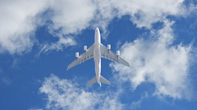 Zoom photo of passenger plane flying above deep blue slightly cloudy sky