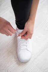 Sportsman tying white sneaker