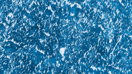 Blue ice surface with scratches and snow