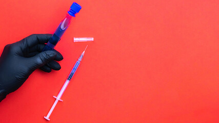 Vaccine isolated. Doctor hand in medical glove hold syringe with needle for protection flu virus and coronavirus. Covid vaccine isolated on red. Medicine plastic vaccination equipment with needle.