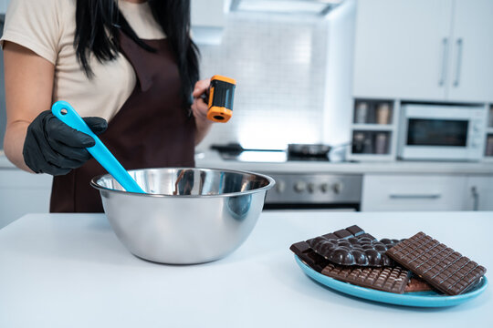 closeup of female measuring temperature of melted chocolate with pyrometer