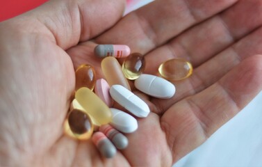 medicines, tablets and capsules in a woman's palm