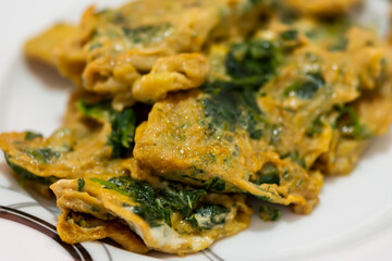 Omelet with nettles served in white plate