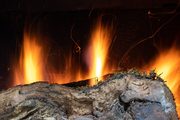 Log burning in a fireplace, with the movement of the flames.