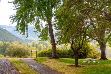 Rain showers fall in a canyon behind a park at the Cataldo State Mission in the Coeur d'Alene area of North Idaho, USA.