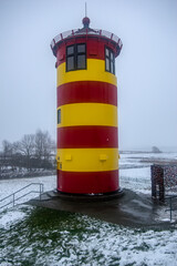 Otto lighthouse in Pilsum in the snow with fog in winter
