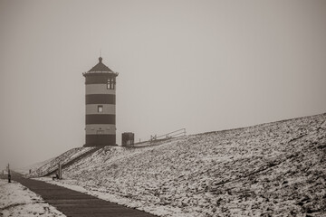 Otto lighthouse in Pilsum in the snow with fog in winter