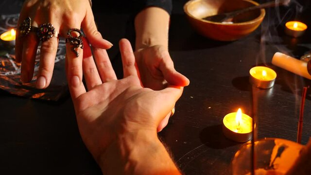 The witch is a fortune teller with candles close-up. A magical ritual. divination. Halloween, 4k, slow-motion.