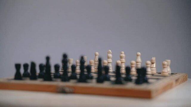 Chess board with exposed pieces, spinning board movement, gray background