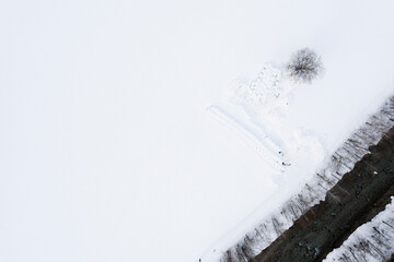 Field with haystacks covered by snow. Bird's eye view