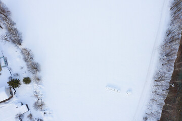 Field with haystacks covered by snow. Bird's eye view