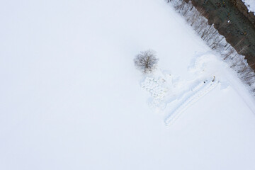 Field with haystacks covered by snow. Bird's eye view