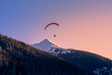 Vibrant Sunset Paragliding Over Majestic Swiss Alps
Paraglider above Swiss alps mountain peak while...