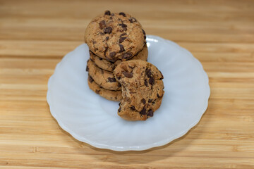 Stack of chocolate chip cookies on a wooden table.