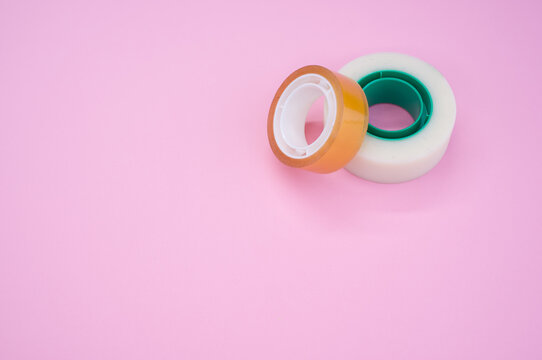 High Angle Shot Of Two Rolls Of Sticky Tapes Isolated On A Pink Background