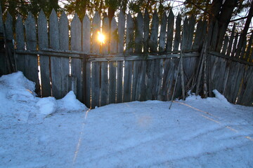Sun shining through the fence in winter