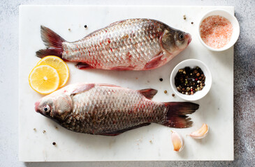 Raw carps with spices on stone slate