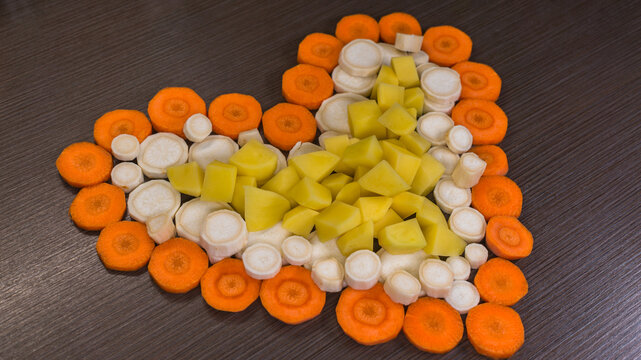 heart shaped vegetables on wooden background / valentines day