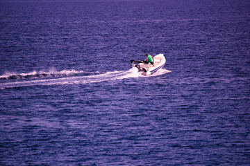 Kreta or Crete, Greece : A man riding on a jet motor boat. waves are formed by speed through water...