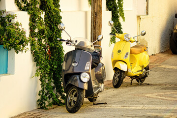 Crete, Greece - September 10, 2017: Vintage old 2 wheeler scooter of different color parked next to wall. Retro scooter parked on a street.