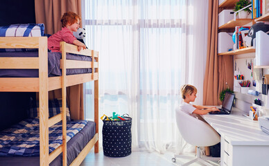 shared kids bedroom with bunk bed, big table and wall shelves, for two boys