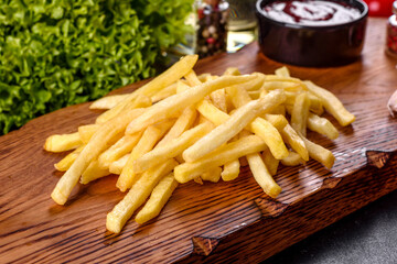 Fresh hot french fries with salt vegetables and spices