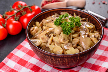 Fresh delicious spicy canned mushrooms with spices and herbs in ceramic dishes
