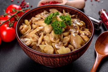 Fresh delicious spicy canned mushrooms with spices and herbs in ceramic dishes