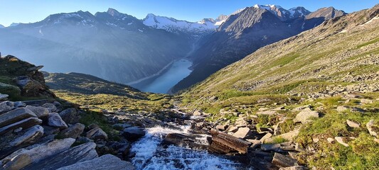 Morning atmosphere next to Olperer hut with views of Alpine lake Schlegeis in the valley Zillertal, Austrian Alps