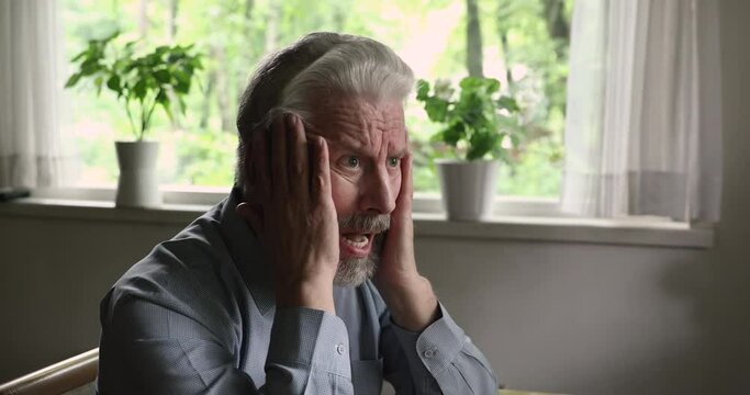 Frustrated stressed middle aged man suffering from mental disease, having psychological problems, morning alone indoors. Unhappy elderly hoary grandfather feeling insecure, thinking of life troubles.