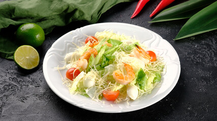 Caesar salad with shrimps on a dark background