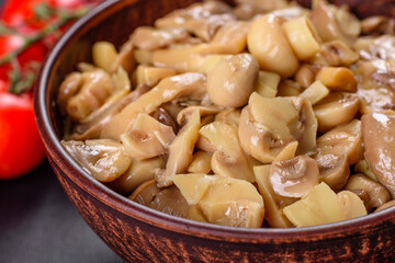 Fresh delicious spicy canned mushrooms with spices and herbs in ceramic dishes